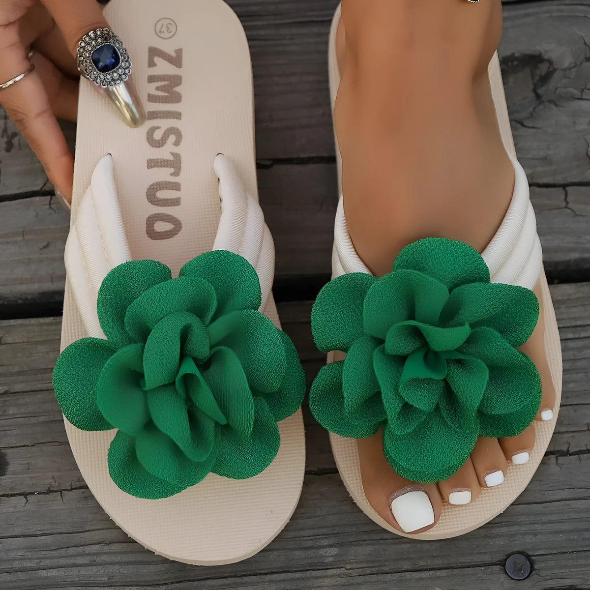 A pair of plus size floral design flip flop slippers in creamy-white with a PU upper and sole.