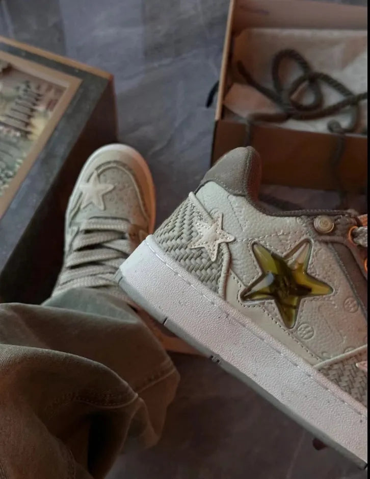 Green low-top casual trainers with star pattern stitching and lace-up closure