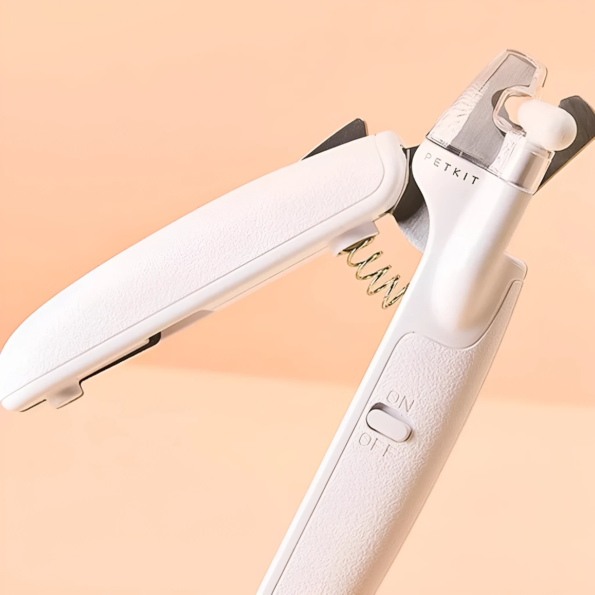White pet nail clipper with LED light on handle and transparent anti-splash guard surrounding the blades.