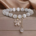 Women's white cat's eye stone bracelet with floral tassel and safety buckle clasp