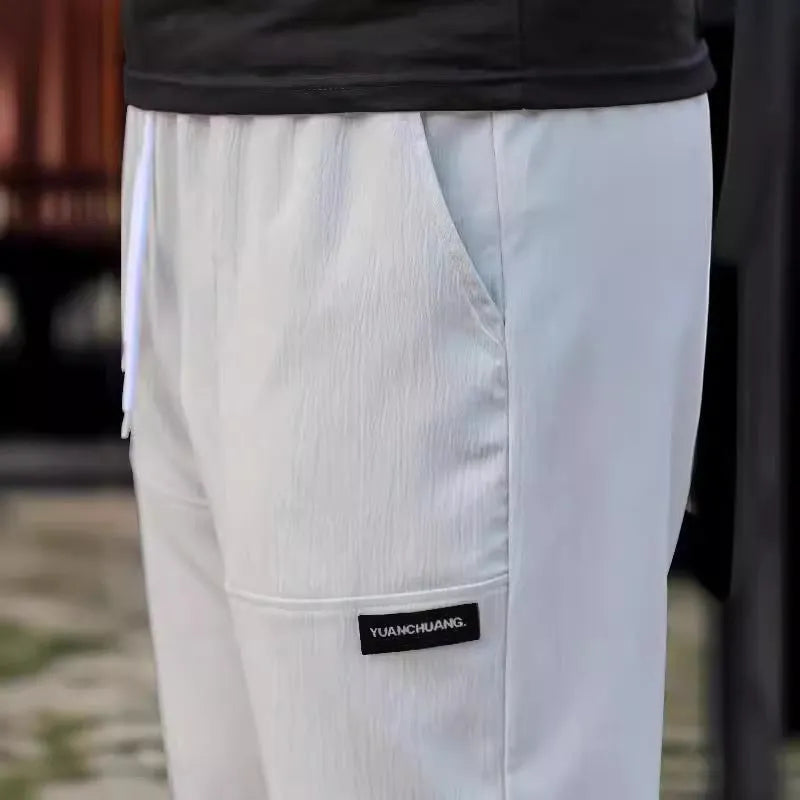 Men's polyester trousers for spring and autumn in light grey colour, showing casual fit.