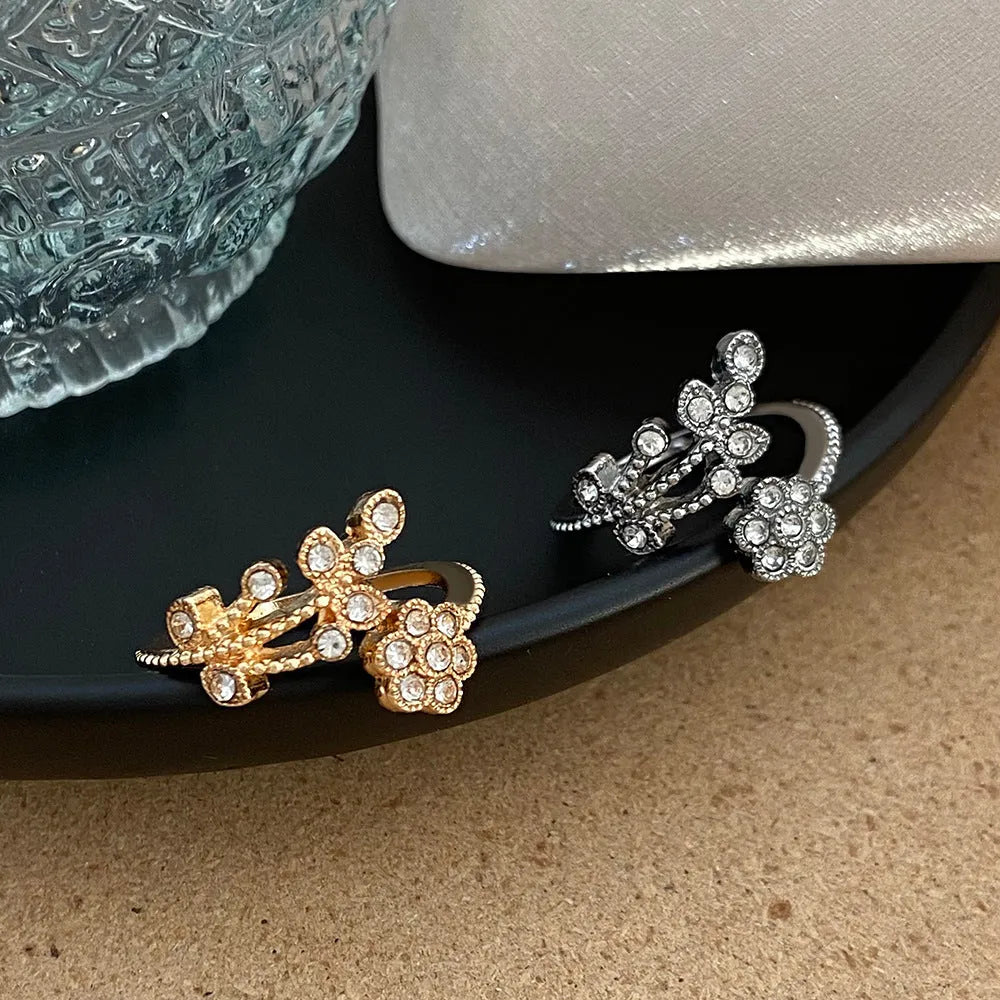 Close-up of a women's open ring with detailed floral leaf engraving, shown in gold colour finish.