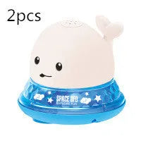 Whale-shaped electric bath toy spraying water with coloured LED lights, shown with base unit on blue background