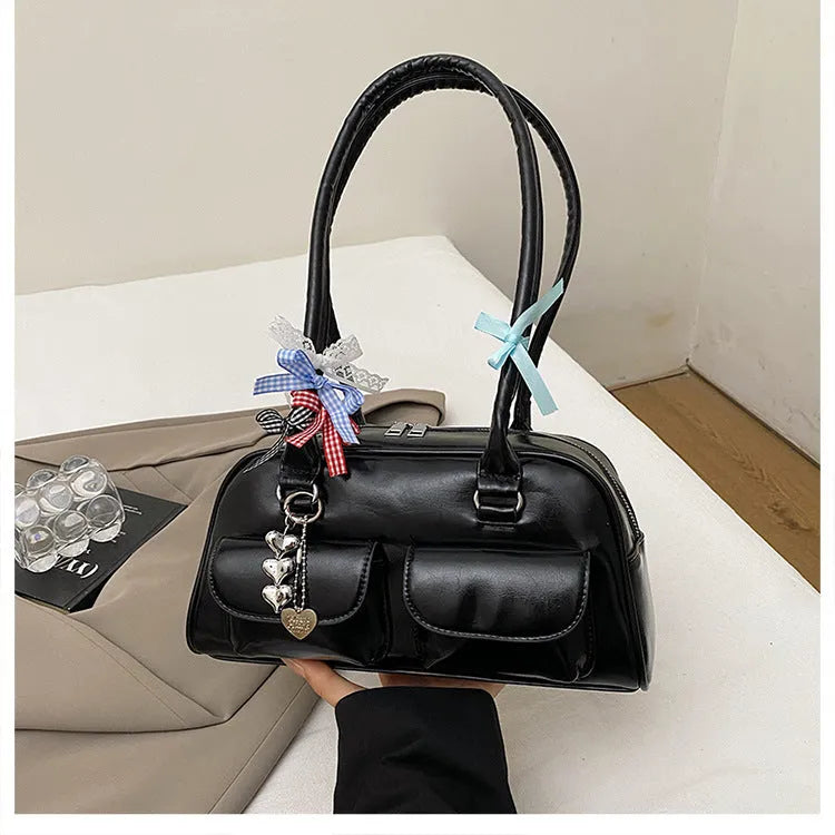 Brown retro-style women's PU leather pillow bag with flap and double strap, shown with ribbon pendant.