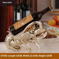 Lobster wine rack ornament in rose gold or silver metallic finish holding bottle
