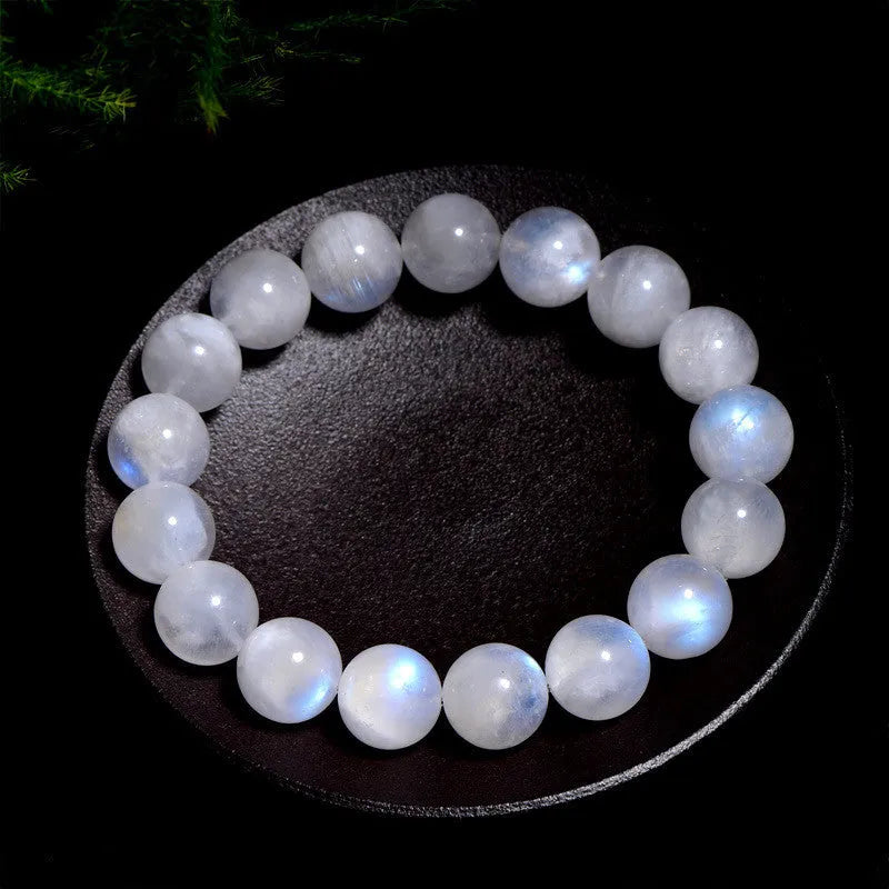 Natural blue polished moonstone round bead bracelet with adjustable clasp on a wrist.