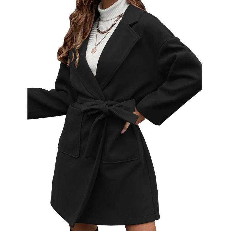 Brown loose-fit long coat with lapel, buttons, belt, and split hem on a model.
