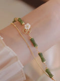 Handmade double layer olivine bracelet with Bells of Ireland charms on a model's wrist