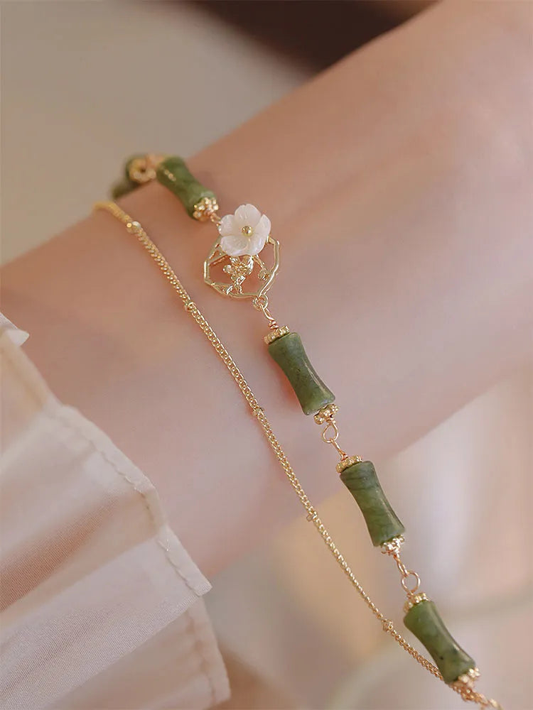 Handmade double layer olivine bracelet with Bells of Ireland charms on a model's wrist