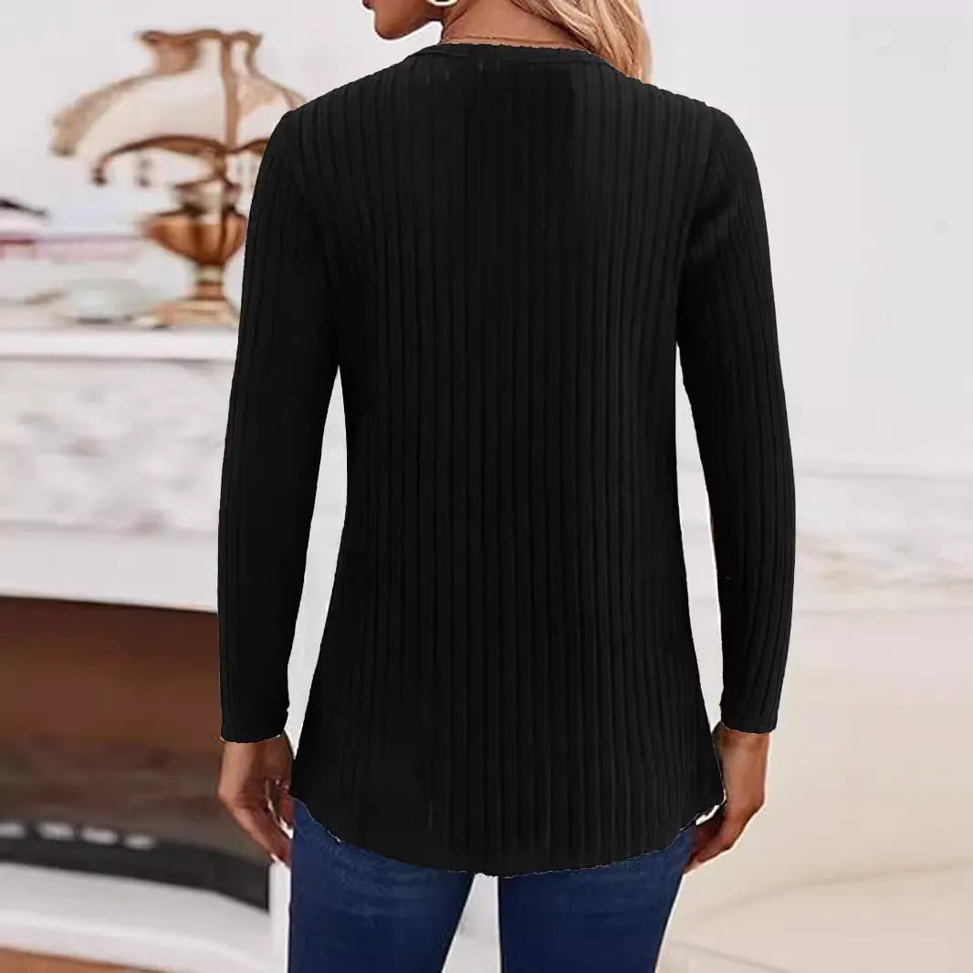 Man wearing a solid grey green knitted pullover sweater with a button detail on the chest.