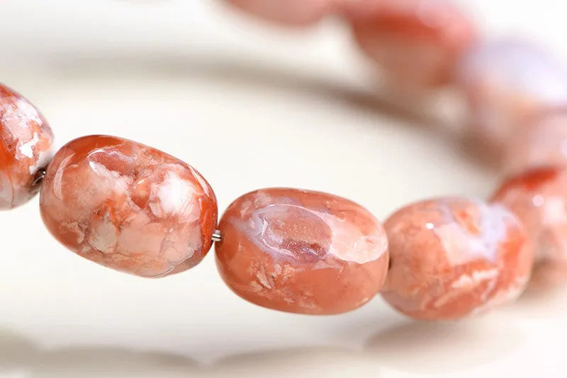 Natural cherry agate barrel bead bracelet with Ruyi elements measuring 10x14mm