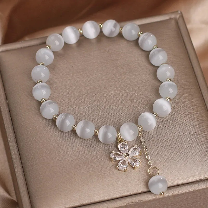 Women's white cat's eye stone bracelet with floral tassel and safety buckle clasp