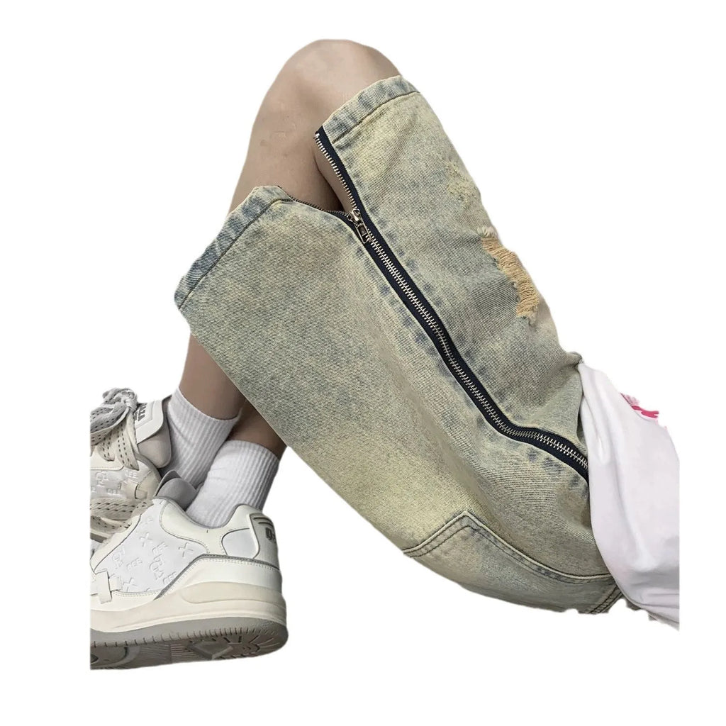Man wearing blue ripped denim shorts with a yellow mud wash and button-fly closure