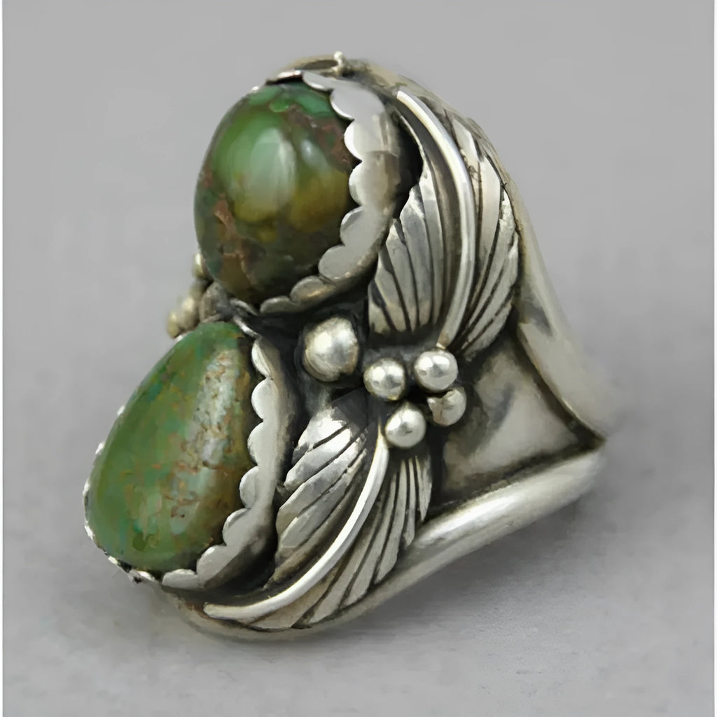 Close-up of a women's turquoise geometric ring with a retro inlaid design on a finger.