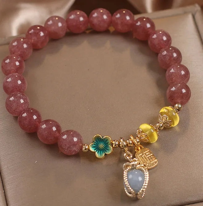 Red women's bracelet with strawberry quartz beads, alloy metal elements, and rhinestone decorative details on adjustable band