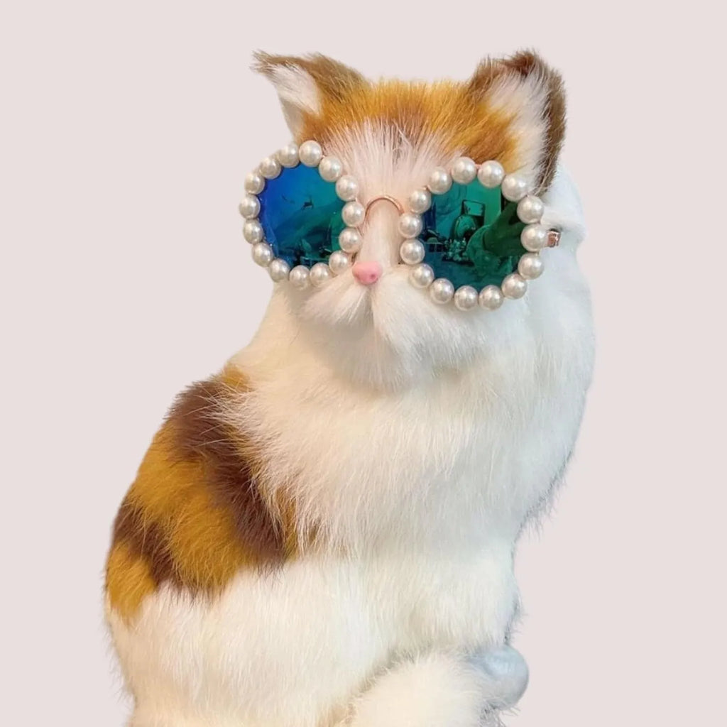 Pearl-rimmed round sunglasses for cats and dogs in multiple colours on a festive background.