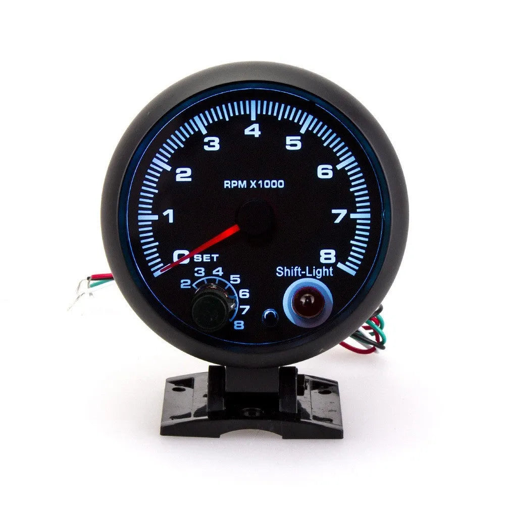 Black automotive tachometer with blue light pointer display and digital readout showing RPM measurement