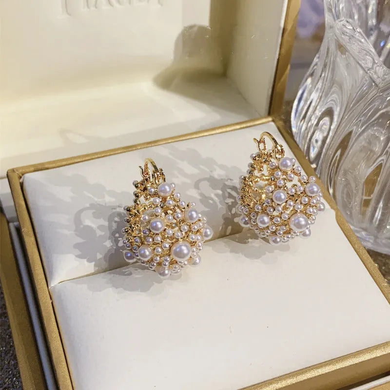 Gold coloured women's flower basket earrings with pearl inlay and small rice-shaped bead details.