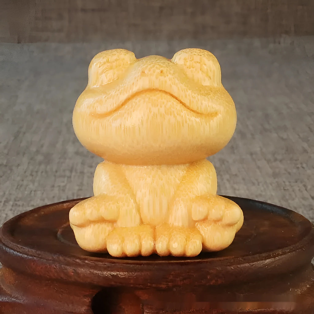 Solid bamboo carving ornament of a smiling frog cartoon character.