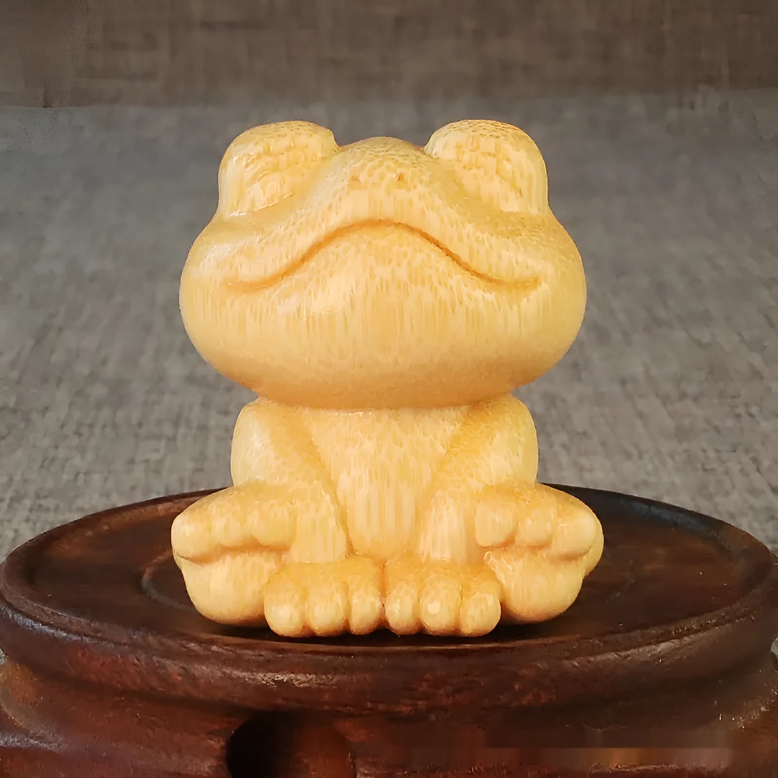 Solid bamboo carving ornament of a smiling frog cartoon character.