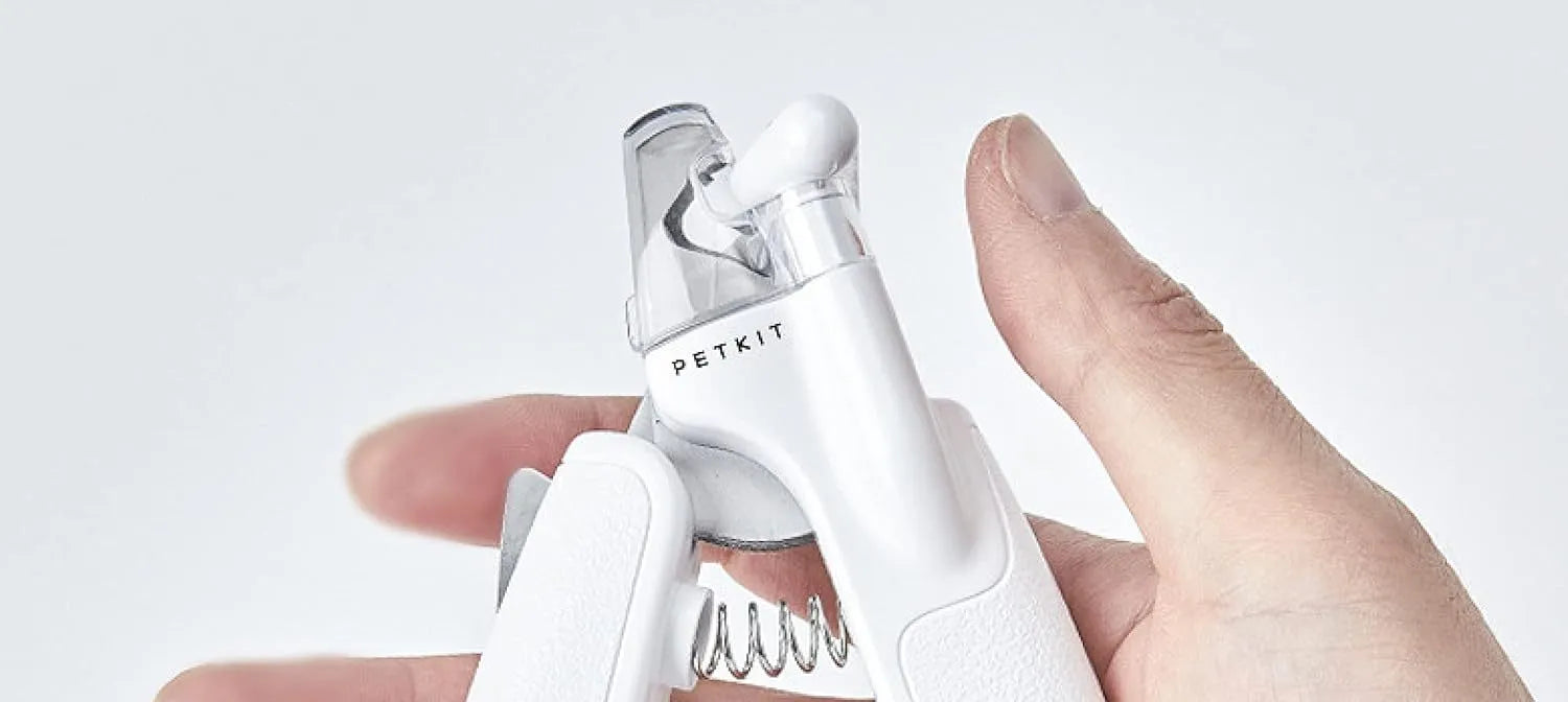 White pet nail clipper with LED light on handle and transparent anti-splash guard surrounding the blades.