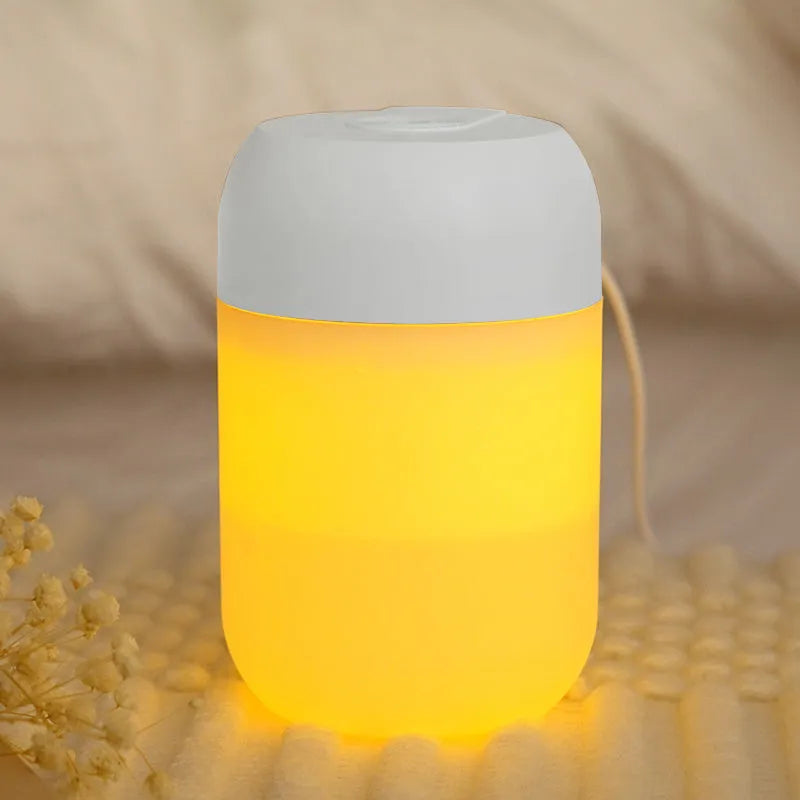 White cylindrical mini humidifier with USB cable on a desk