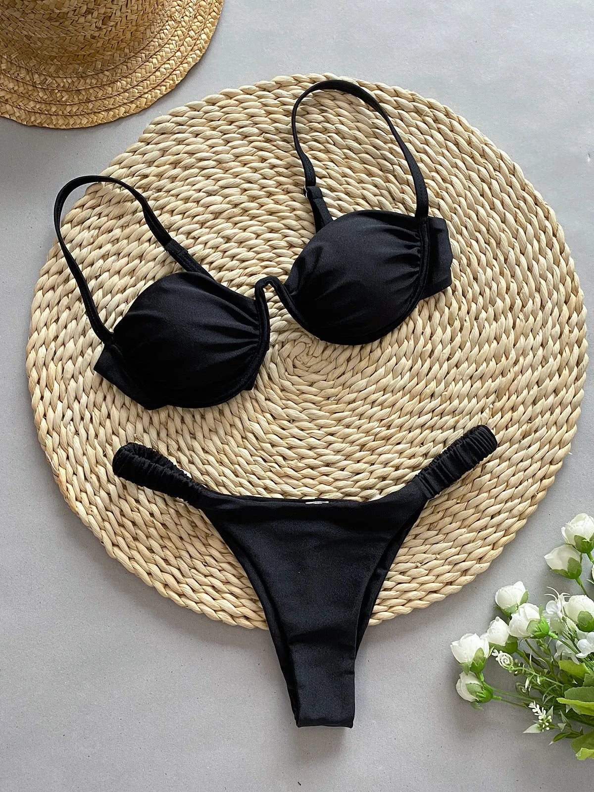 Women's black underwire bikini swimsuit with briefs on a neutral background