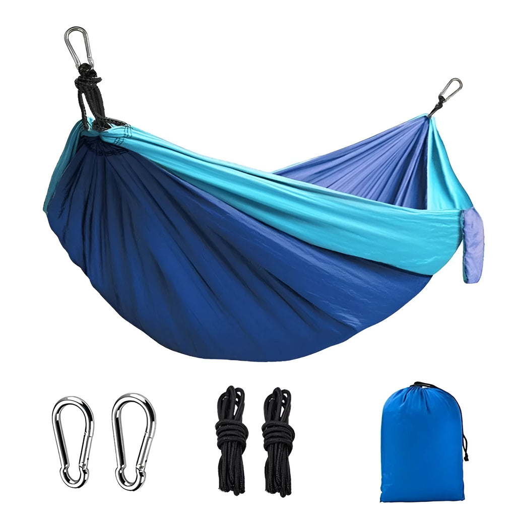 Blue outdoor camping hammock made from parachute nylon fabric, hanging between two trees.