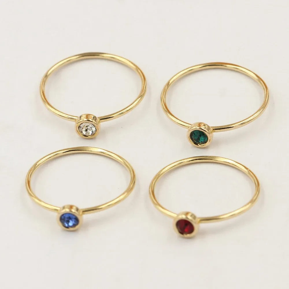 Women's copper knuckle ring with gilded finish and zircon stones in green, blue, red, and white.