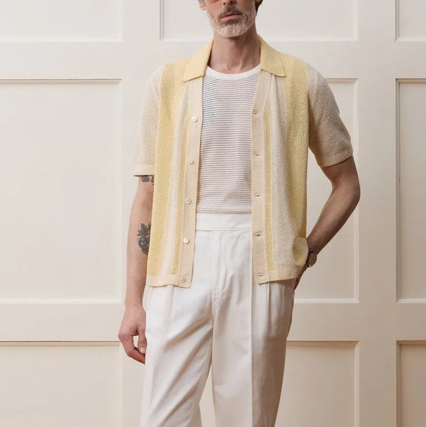 Yellow asymmetric hollow-out short-sleeved polo shirt on a hanger