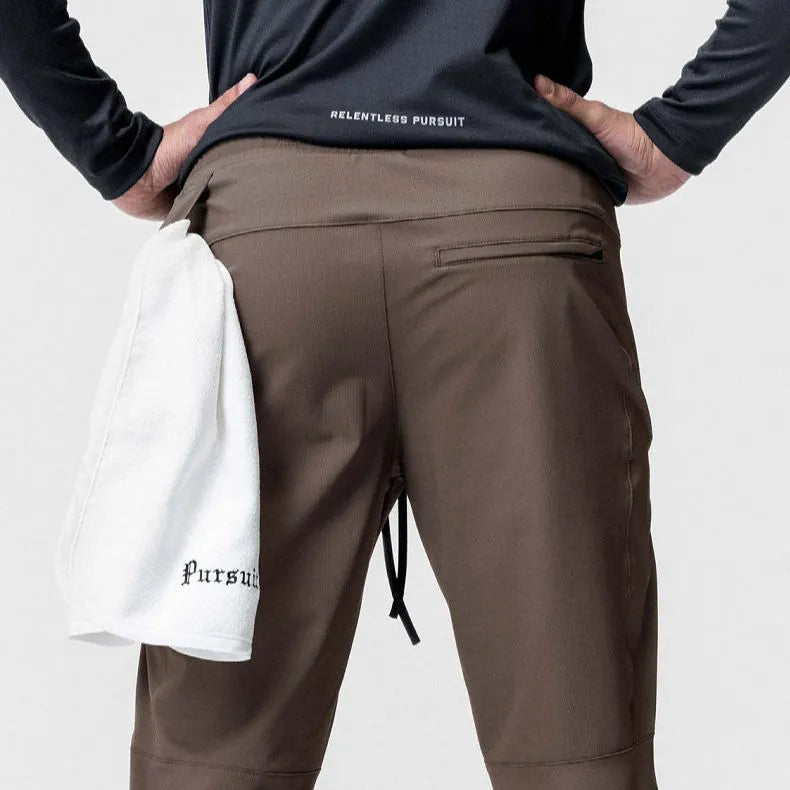 Man wearing loose grey ankle-tie fitness trousers suitable for running and gym workouts.