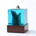 Clear epoxy resin night light ornament with a shark surfer scene inside, shown in 5cm and 8cm sizes.