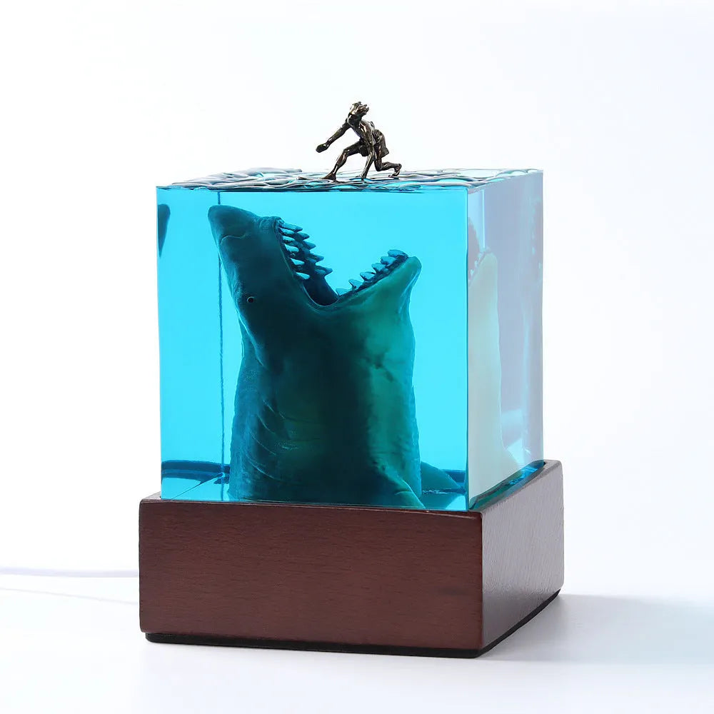 Clear epoxy resin night light ornament with a shark surfer scene inside, shown in 5cm and 8cm sizes.