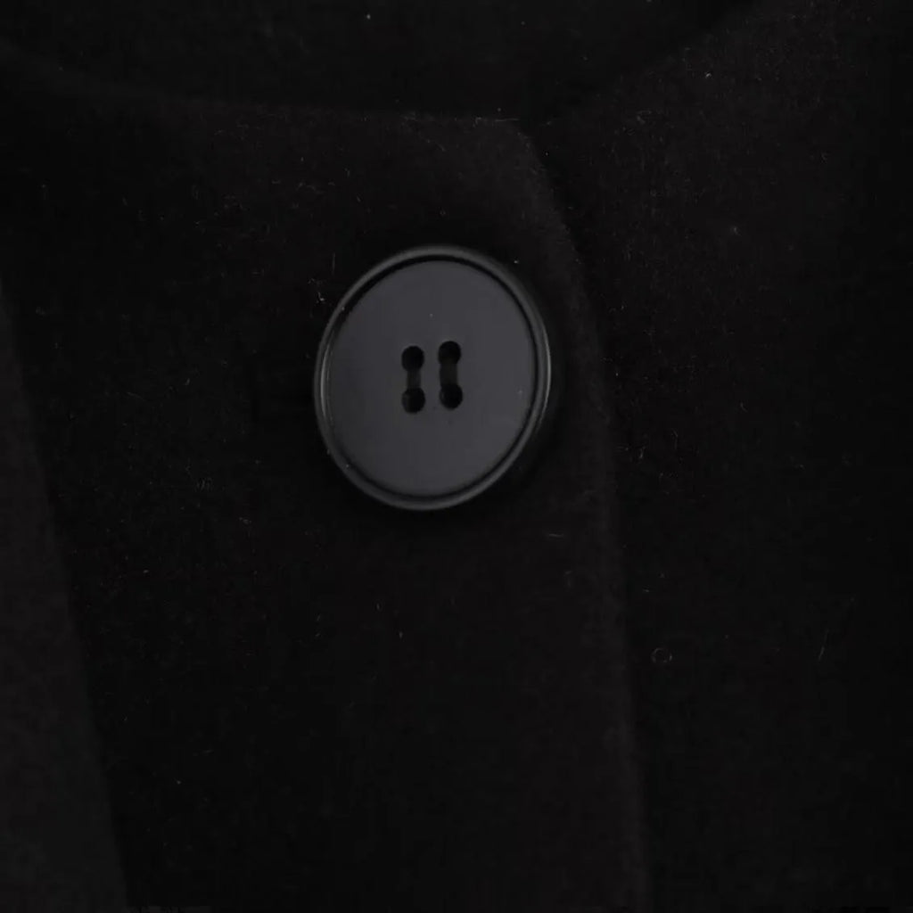Women's long black polyester overcoat with artificial fur collar and pockets, showing extended length.