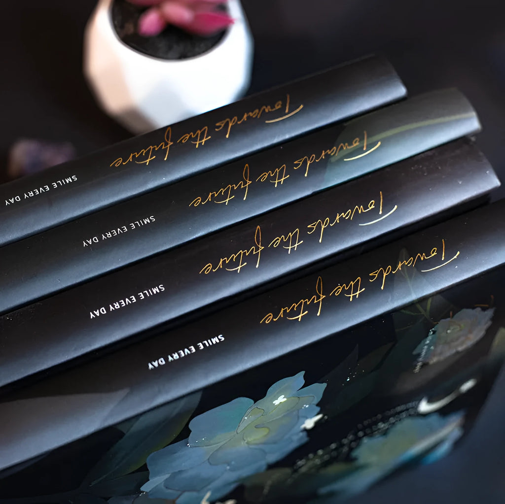 A5 notebook with luminous cover open to show colour illustrated pages, available in four colours.
