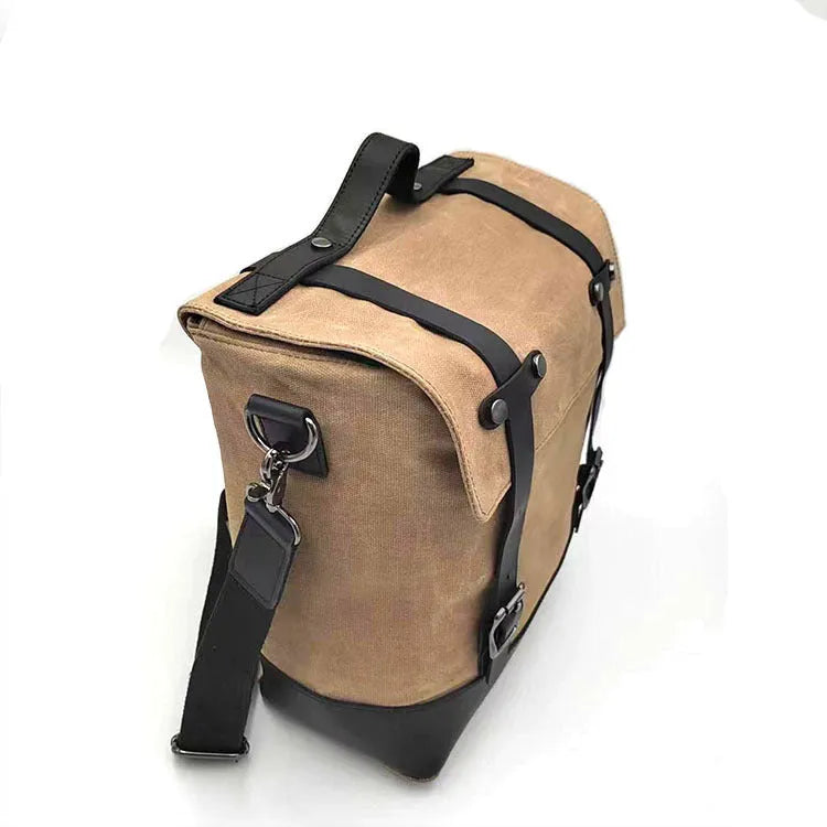 Black waterproof canvas motorcycle side bag with cowhide details mounted on motorcycle