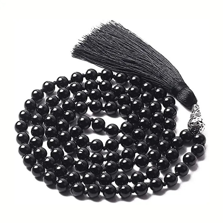 Long blue patterned agate and stone tassel necklace with geometric beads on a white background.