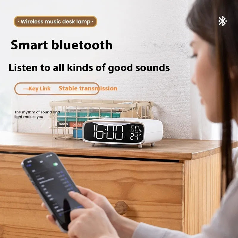 White wireless charging stand with built-in Bluetooth speaker and night light on bedside table