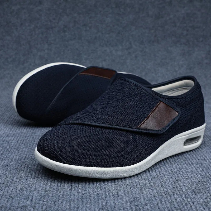 Beige and grey leisure shoes with a wide fit and a black velcro strap closure.