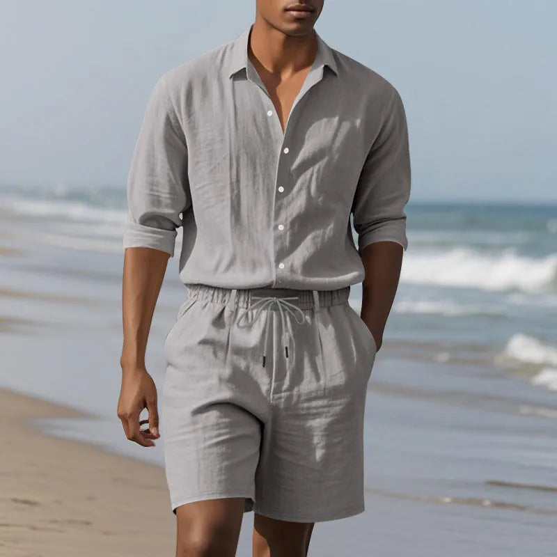 A man wearing a light blue linen long sleeve shirt and matching shorts from the beach suit set.