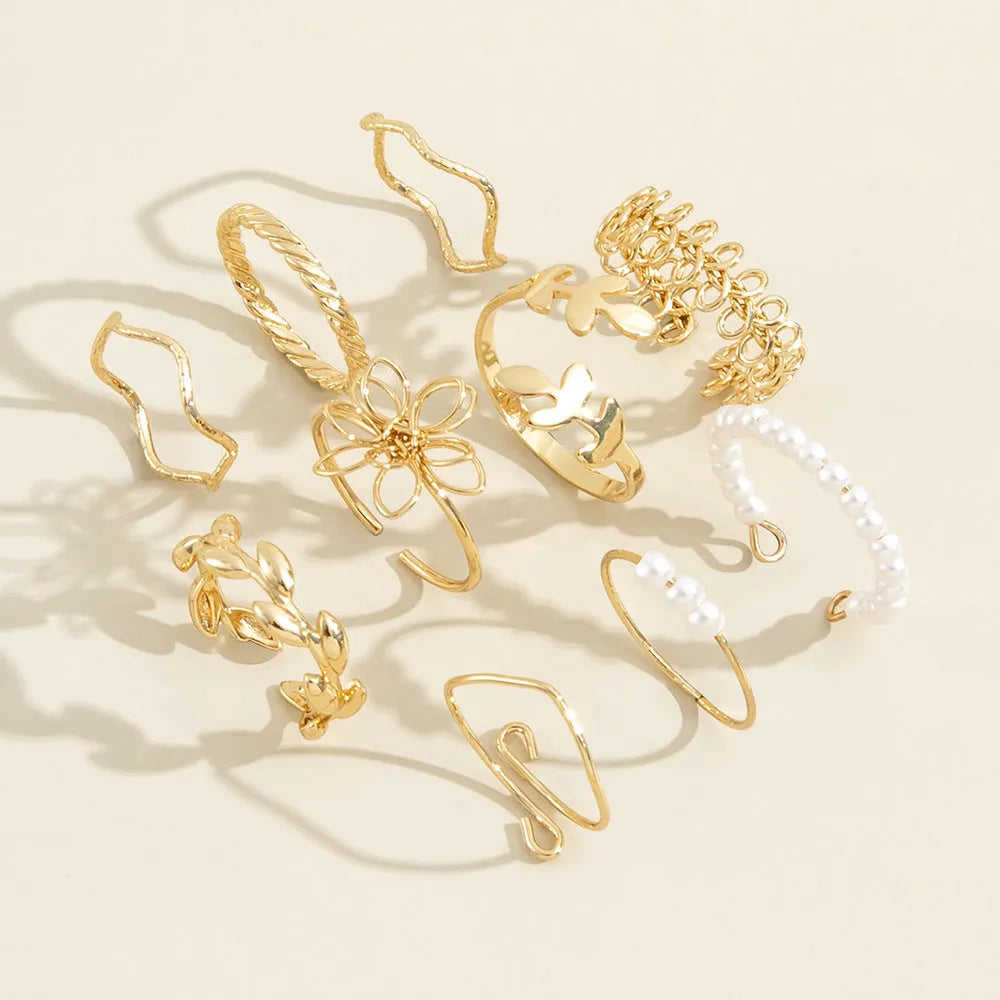 Gold coloured openwork flower shape alloy ring with a glossy electroplated finish.