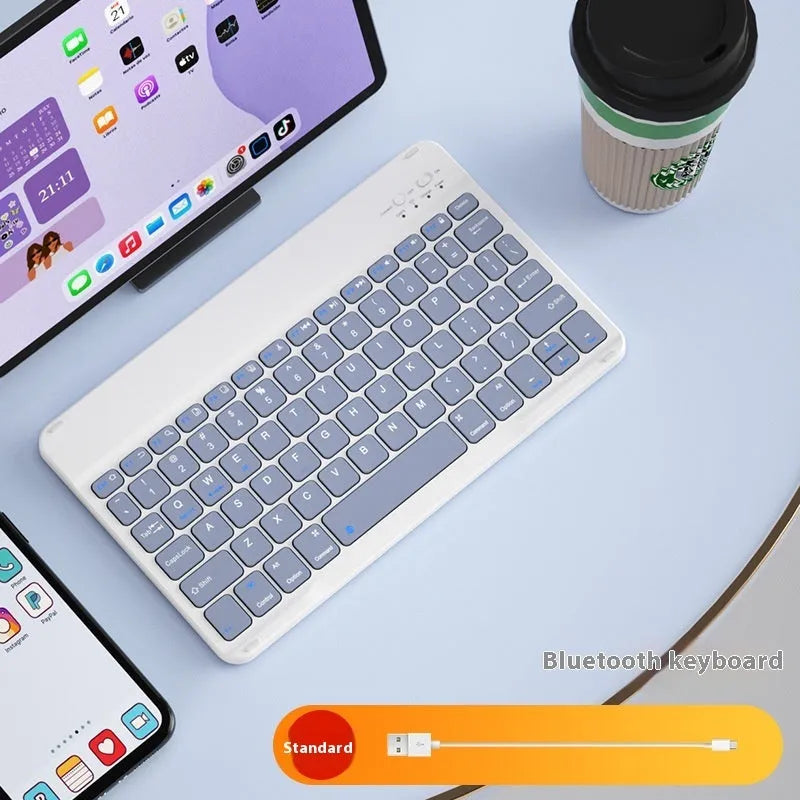 Compact white Bluetooth keyboard for tablet and PC use on a wooden desk