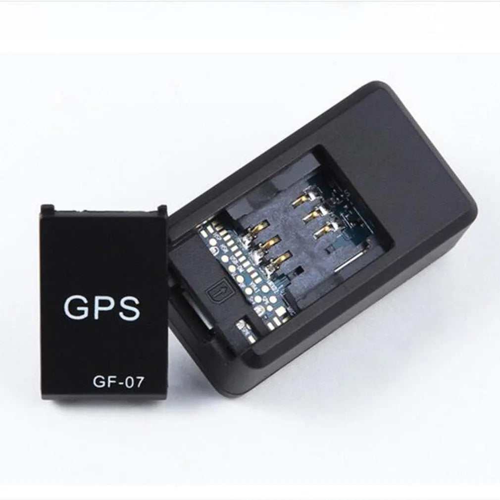 Small black plastic magnetic GPS tracker device with USB charging cable.