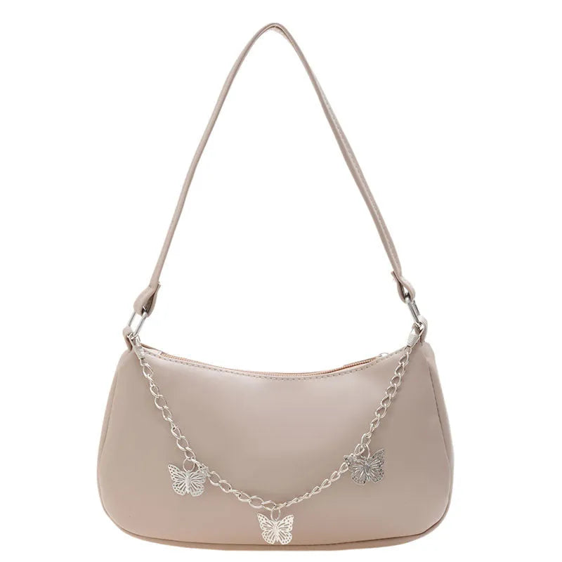 Women's black butterfly chain underarm bag with crossbody strap, showing structured square shape and retro style.
