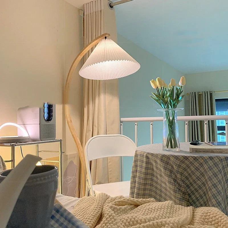 Retro-style vertical table lamp with log white lampshade placed on a sofa arm.