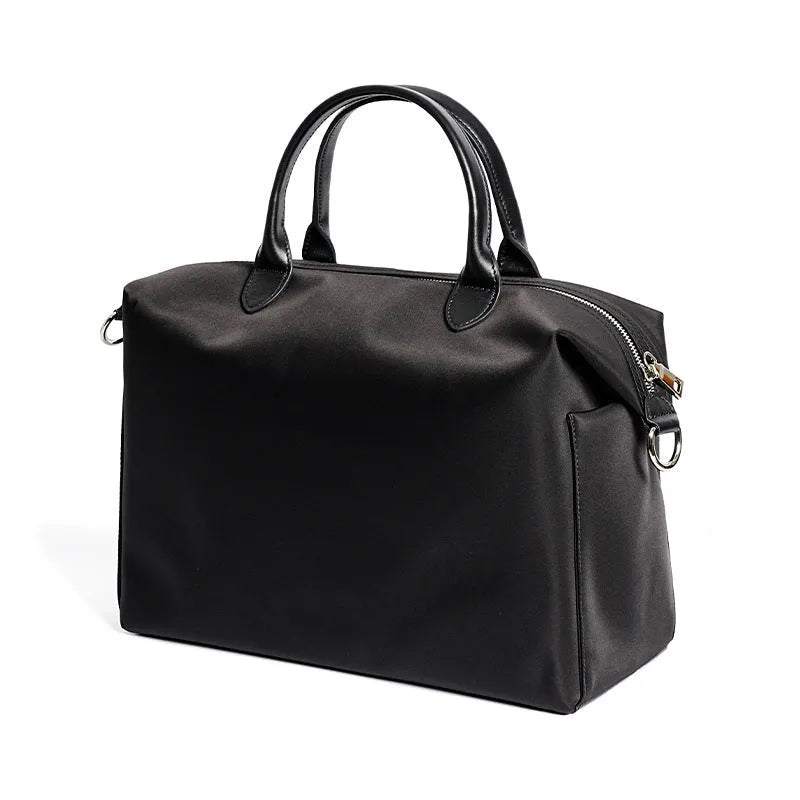 Black nylon waterproof shoulder bag with leather handbag detail and large main compartment.