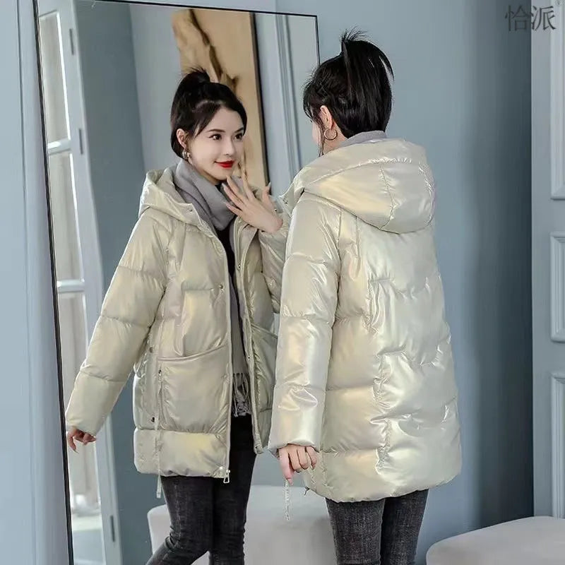 Women's green thick loose fit hooded winter jacket with long sleeves on a hanger.
