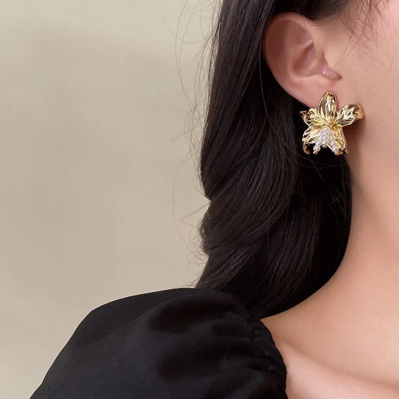 Gold H1795 pearl flower earrings with floral design on a white background.