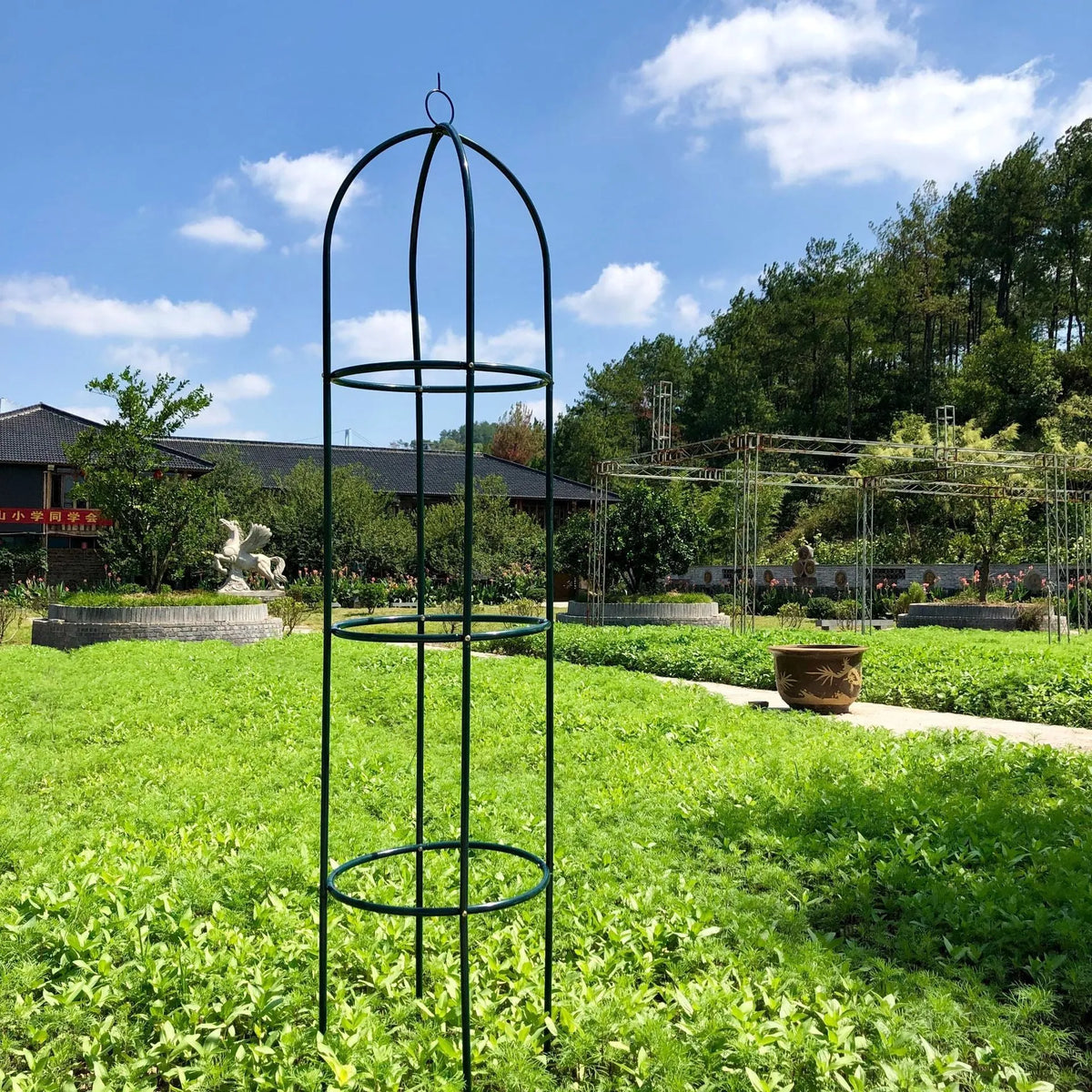 Dark green European-style wrought iron plant climbing frame lattice standing on floor.