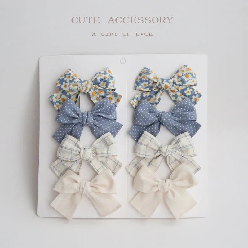 Set of children's cloth hair clips with a dovetail bow design in various colours.